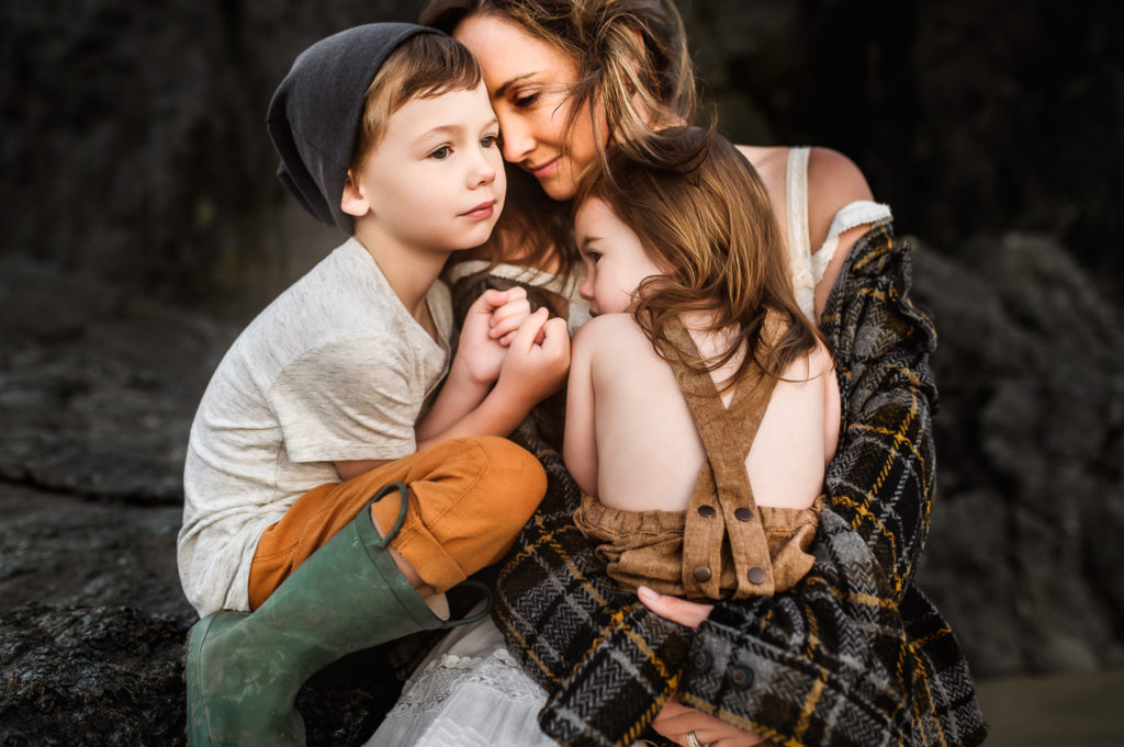 Family Photographer, a mother happily holds her two young children outside