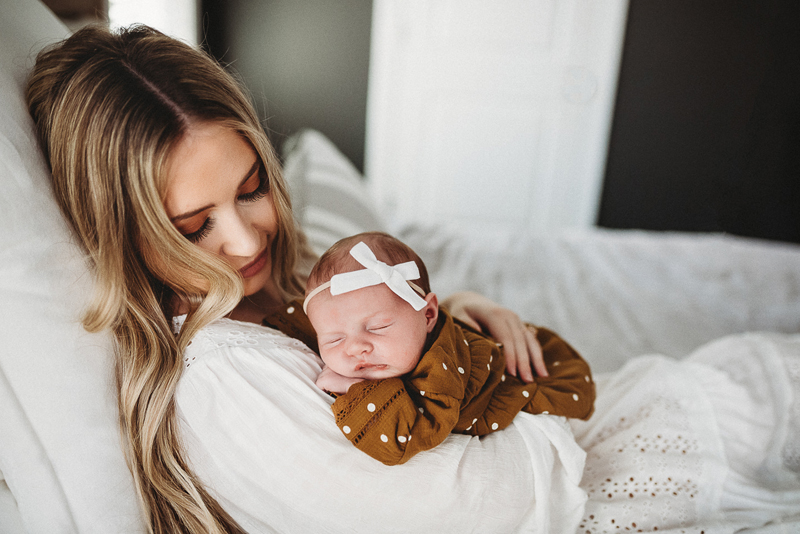 Newborn Photographer, A new mother holds her new baby daughter
